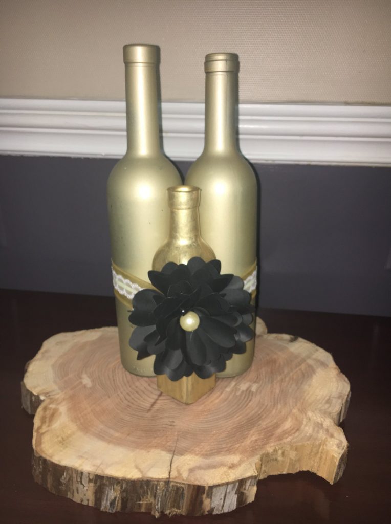 Wine Bottle Centerpiece Tips, Gold bottle with black paper flower